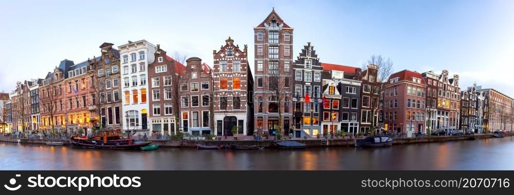 Panoramic view of the city embankment and facades of houses at sunset. Amsterdam. Netherlands.. Panorama of the city waterfront of Amsterdam at sunset.