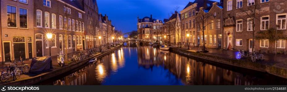 Panoramic view of the city embankment and the facades of houses at sunrise. Leiden. Netherlands.. Panorama of the city embankment in Leiden at sunrise.