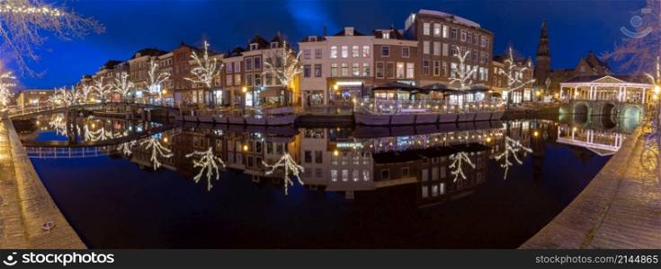 Panoramic view of the city embankment and the facades of houses at sunrise. Leiden. Netherlands.. Panorama of the city embankment in Leiden at dawn.