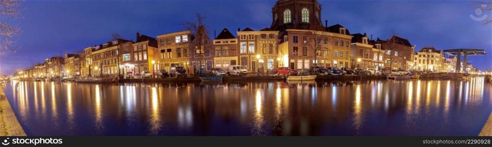 Panoramic view of the city embankment and the facades of houses at sunrise. Leiden. Netherlands.. Panorama of the city embankment in Leiden at sunrise.