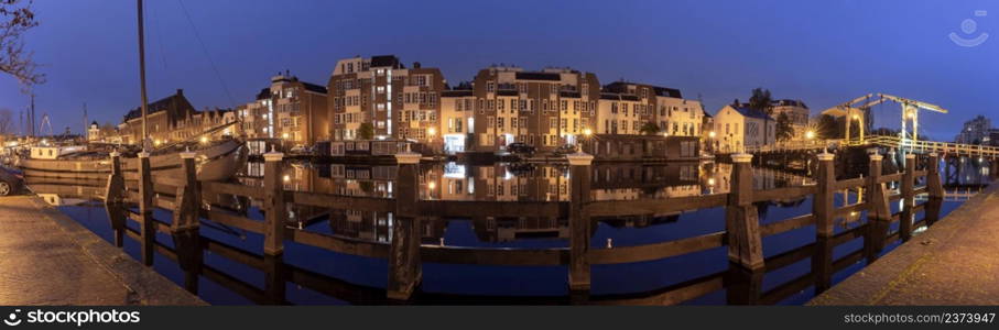 Panoramic view of the city embankment and the facades of houses at sunrise. Leiden. Netherlands.. Panorama of the city embankment in Leiden at sunrise.