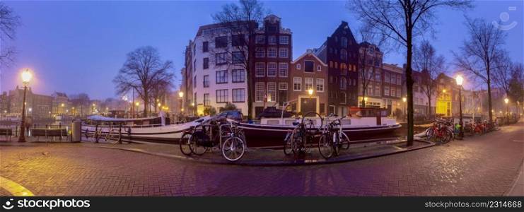 Panoramic view of the city embankment and the facades of houses in the fog on the Amstel canal. Amsterdam. Netherlands.. Panorama of the city waterfront of Amsterdam on a foggy morning.