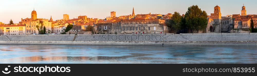 Panoramic view of the city embankment and the old historical part of the city at sunset. Arles. Provence. France.. Arles. Panoramic view of the city promenade and the city at sunset.
