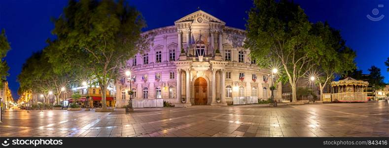 Panoramic view of the facade and the square in front of the city hall in night illumination at dawn. Avignon. France. Provence.. Avignon. Panorama. City Hall building at dawn.