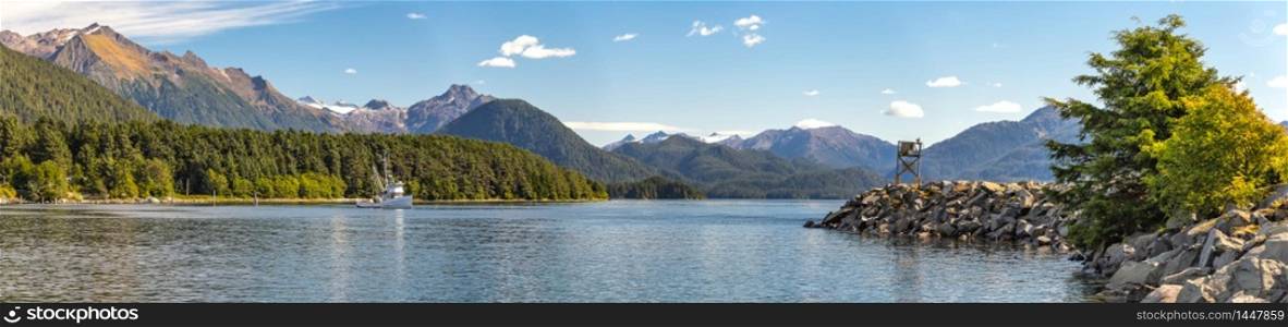 Panoramic view of the harbor with a fishing boat sailing in the distance in Sitka, Alaska.