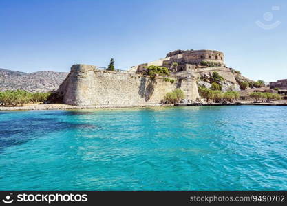 Panoramic view of the island of Spinalonga with calm sea. Here were isolated lepers, humans with Hansen’s disease, gulf of Elounda, Crete, Greece.. Panoramic view of the island of Spinalonga with calm sea.