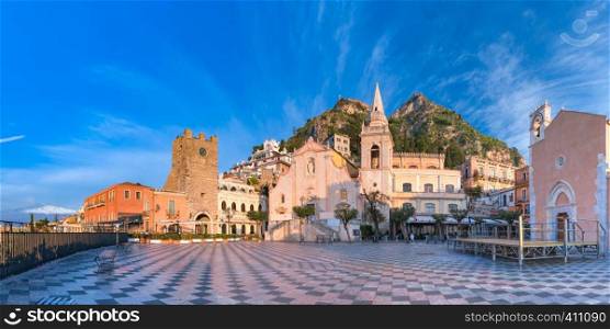 Panoramic view of the morning square Piazza IX Aprile with San Giuseppe church, the Clock Tower and Mount Etna Volcano on background, Taormina, Sicily, Italy. Piazza IX Aprile, Taormina, Sicily, Italy