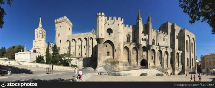 Panoramic view of the Palais des Papes in the city of Avignon in southeast France in the department of Vaucluse on the left bank of the Rhone River. Once a fortress and palace, the papal residence was the seat of western Christianity during the 14th century. Since 1995, the Palais des Papes, along with the historic center of Avignon, is a UNESCO World Heritage Site.