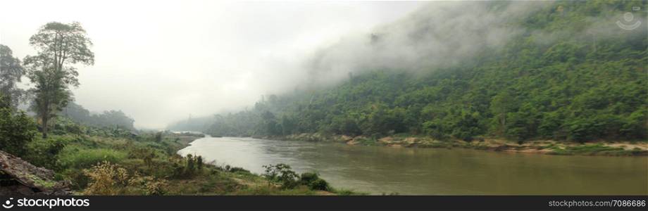 panoramic view of the Salween River twisting along a cloud covered mountain range near Myanmar, Southeast Asia