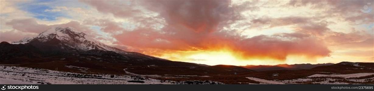 Panoramic view of the snowy Chimborazo volcano and its surroundings in a cloudy sunset. Ecuador. Panoramic view of the snowy Chimborazo volcano and its surroundings in a cloudy sunset