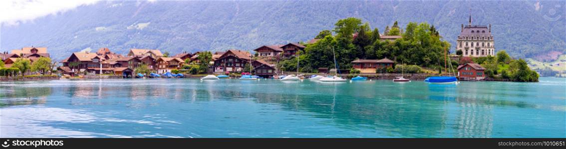 Panoramic view of the traditional Swiss village of Iseltwald on the famous Brienz Lake. Switzerland.. Panorama of the Swiss village of Iseltwald on the famous Lake Brienz. Switzerland.
