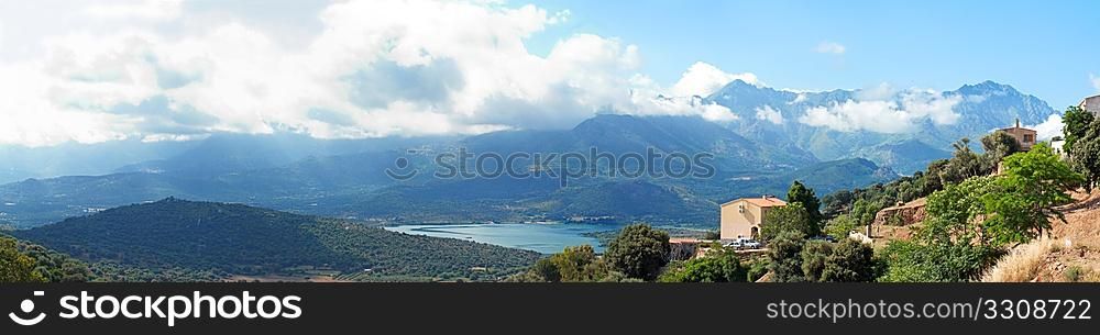 panoramic view of villa in Corsica with mountains and lake in background