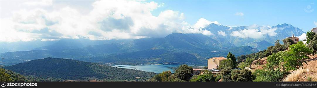 panoramic view of villa in Corsica with mountains and lake in background