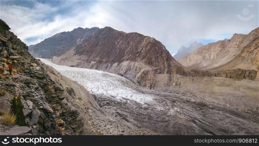 Panoramic view of white Passu glacier and glacial moraine, surrounded by mountains in Karakoram range. Gojal Hunza. Gilgit Baltistan, Pakistan.