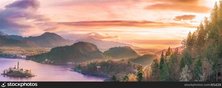 Panoramic view with the Bled island, the lake and the surrounding hills, in amazing colors due to the sunrise. Slovenia is a wonderful place to visit.
