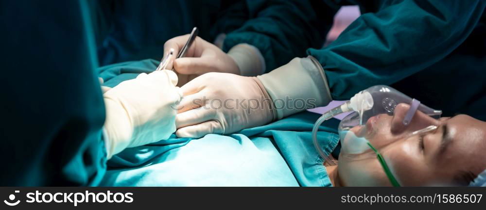 Panoramic web banner crop Close up Surgeon doctor and nurse performing Surgical Operation to patient with his team in Operating Room OR. Medical health care Surgery concept.