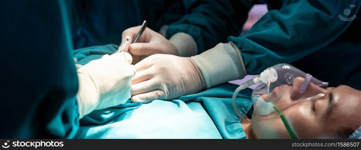 Panoramic web banner crop Close up Surgeon doctor and nurse performing Surgical Operation to patient with his team in Operating Room OR. Medical health care Surgery concept.