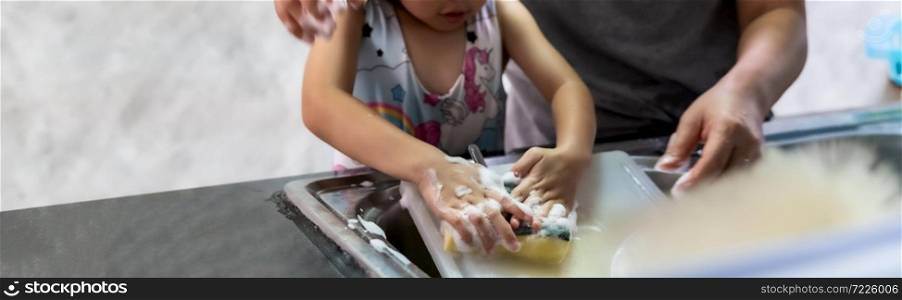 Panoramic web banner of asian girl washing dish and tableware with her mom, housework for child make executive function for kid. Houseworking for kid lifstyle and family concept.