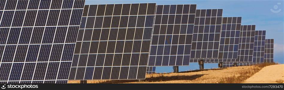 Panoramic web banner of photovoltaic solar panels providing alternative green energy