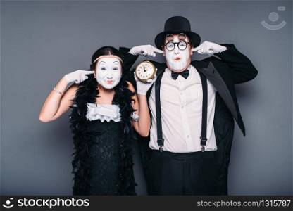 Pantomime actors performing with alarm clock. Comedy artist and actress waiting for bomb explosion. Mime theater performers . Pantomime actors performing with alarm clock