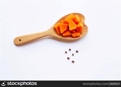 Papaya on wooden spoon on white background.