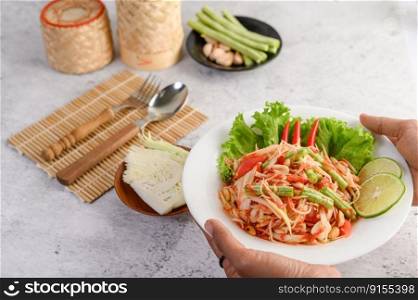 Papaya salad is a traditional Thai food that can be eaten all over the country. Papaya salad with many ingredients such as yard long beans, peanuts, dried shrimp, lime can be eaten with sticky rice.