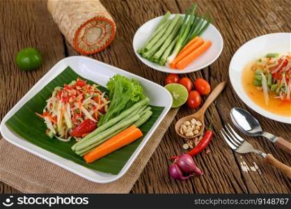 Papaya Salad  Som tum Thai  on a white plate on a wooden table.