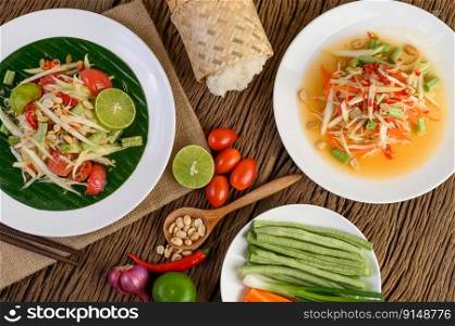 Papaya Salad  Som tum Thai  on a white plate on a wooden table.