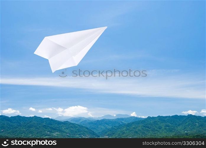 Paper airplane flying upon the mountain toward sky