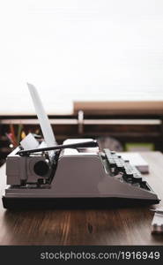 Paper and vintage old typewriter at wooden desk table. Writer or screenwriter creative concept