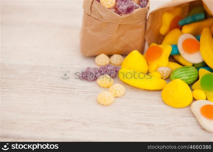 Paper bags stuffed with candy on a gray wooden background