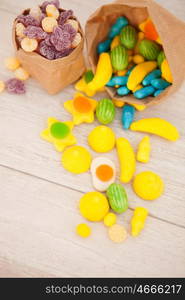 Paper bags stuffed with candy on a gray wooden background