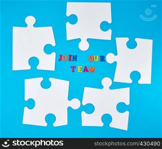 paper blank white puzzle on a blue background, the inscription join our team, the concept of recruitment. Teamwork business concept.