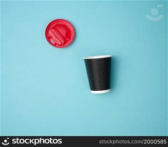 paper brown cardboard cup and red plastic lid on blue background, top view