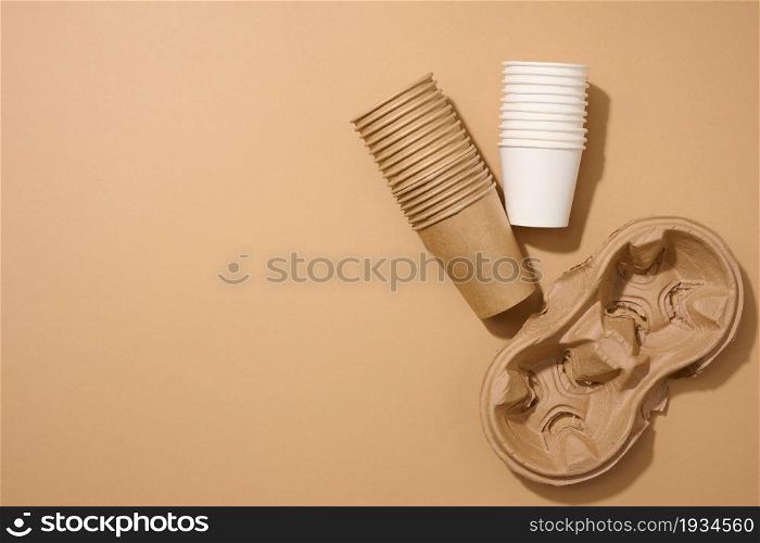 paper brown disposable cardboard cup and holder on brown background. View from above