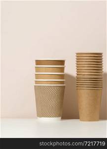 paper cardboard brown cups for coffee and tea, beige background. Eco-friendly tableware, zero waste
