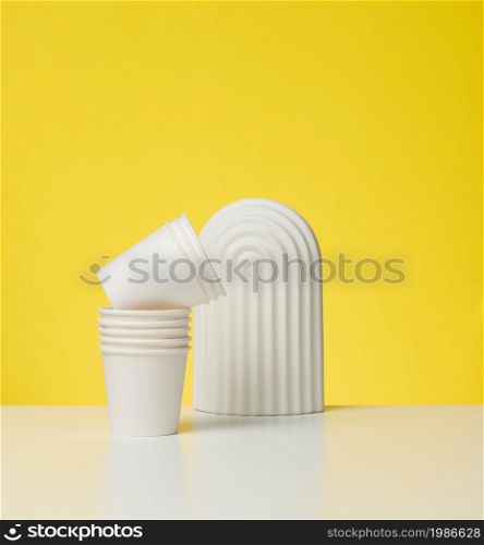 paper cardboard white cups for coffee, yellow background. Eco-friendly tableware, zero waste