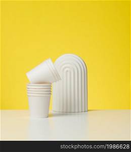 paper cardboard white cups for coffee, yellow background. Eco-friendly tableware, zero waste