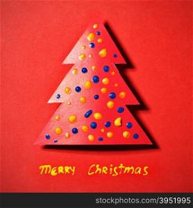 Paper Christmas tree on red background and wishes
