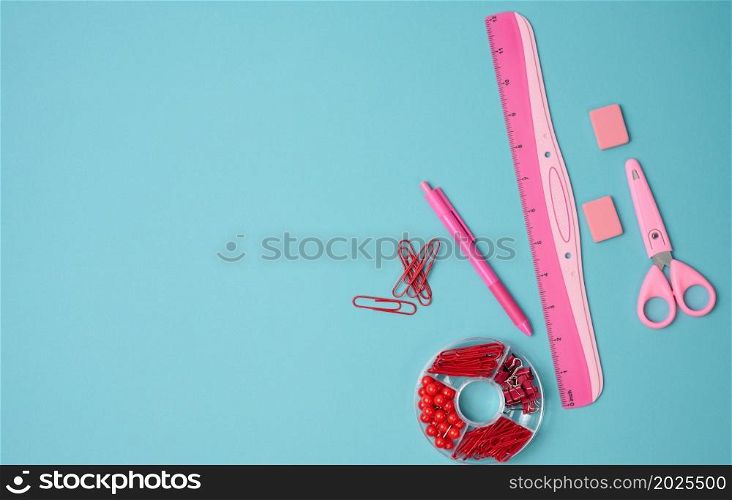 paper clips, buttons, scissors on blue background, top view