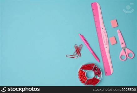 paper clips, buttons, scissors on blue background, top view