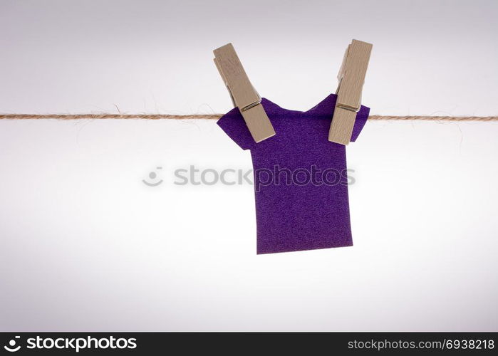 Paper clothes hang on a rope with the help of clothespins