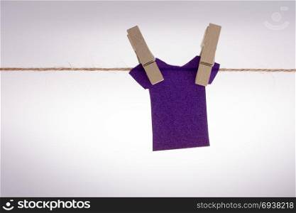 Paper clothes hang on a rope with the help of clothespins