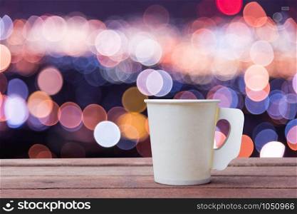 Paper cup coffee on the wooden table with bokeh background