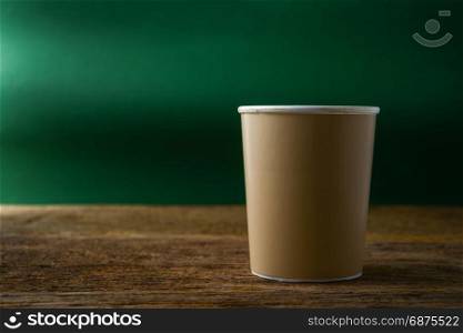 paper cup of coffee on wooden table