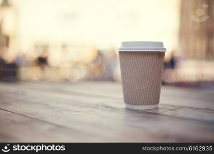 Paper cup on wooden table on street food festival