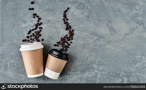 Paper cups for coffee, coffee beans in the form of rising steam. Gray neutral background, top view with copy space. Flat lay takeaway coffee or hot drinks. Minimalism