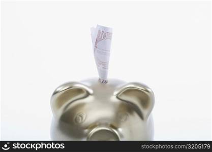 Paper currency sticking out of a piggy bank