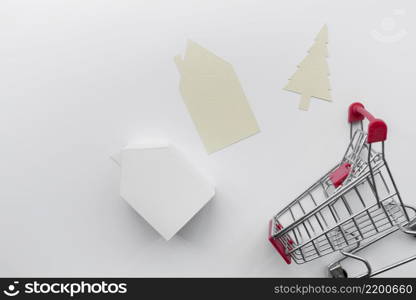 paper cut out house christmas tree with miniature house model shopping cart isolated white background