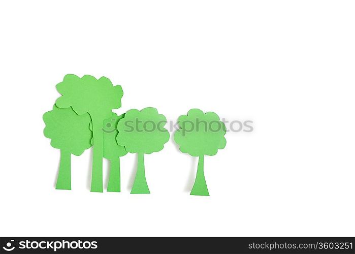Paper cut outs of green trees over white background